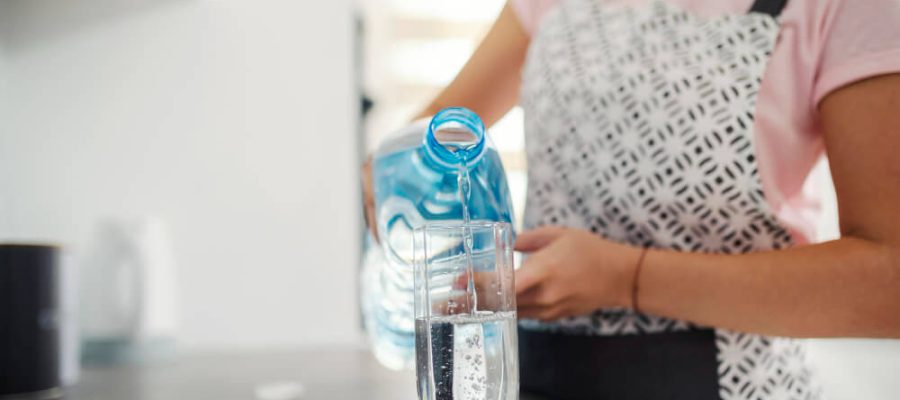 cerca-mujer-vertiendo-agua-dulce-cocina-1